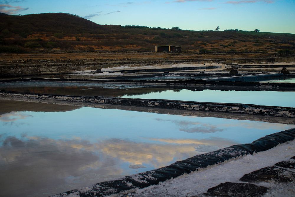 Le ciel se reflète dans les bassins des salines au pied de la colline